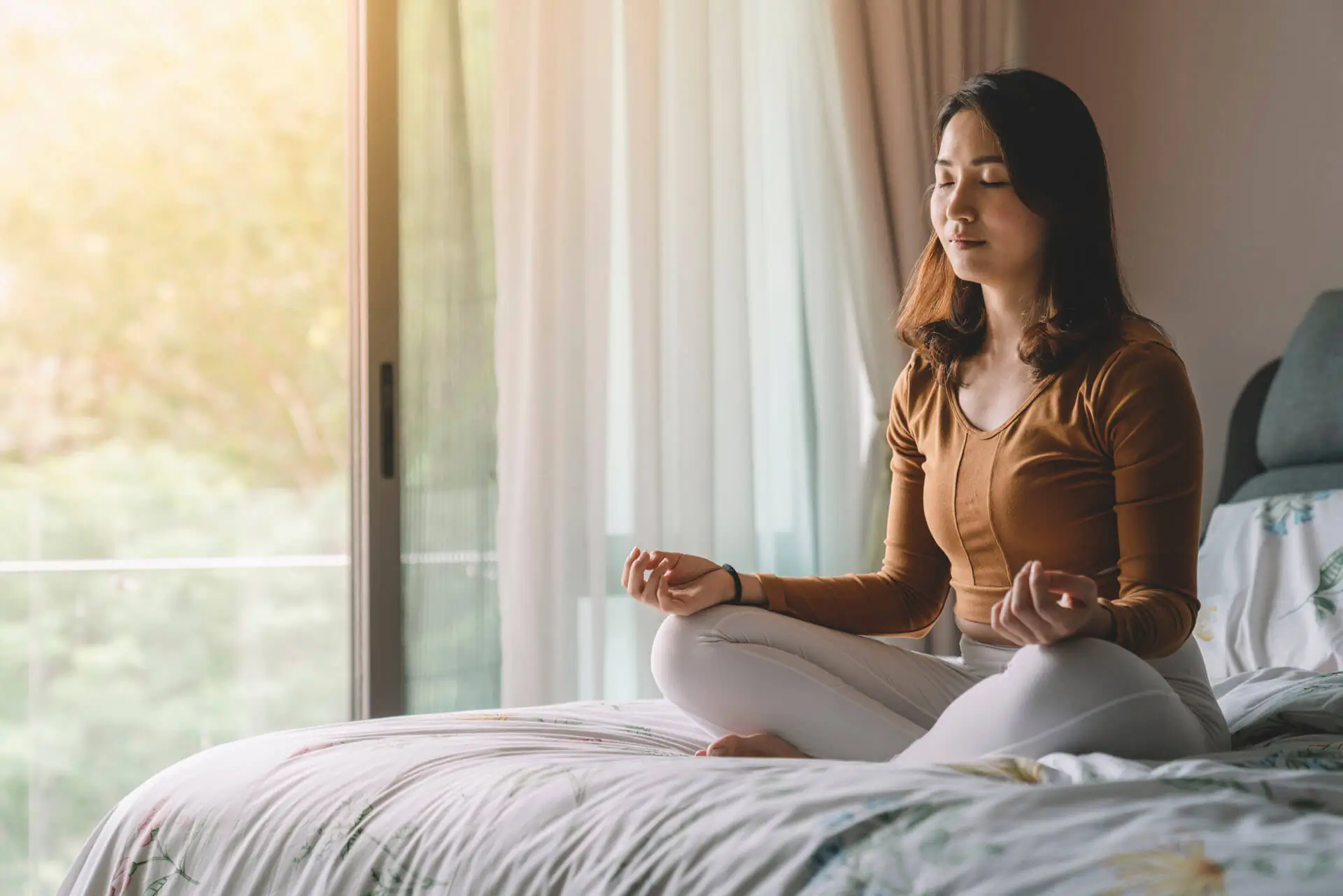 Woman meditating in the bedroom
